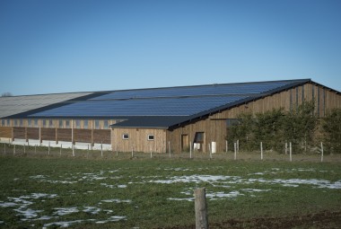 Bâtiment d'élevage en bois (charpente laméllé-collé et bardage douglas) équipé de panneaux solaires.